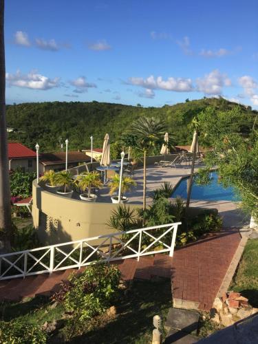 a view of a resort with a pool and a bridge at Swimming Pool- Balcony Veranda- Sea & Sunset Views in Dickenson Bay