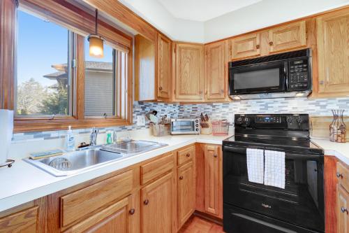 a kitchen with wooden cabinets and a black appliance at Chetola Cardinal 201 in Blowing Rock