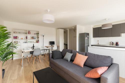 sala de estar con sofá y cocina en DIFY Bollier - Quartier Gerland, en Lyon