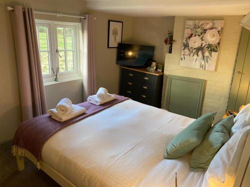 a bedroom with a large bed with towels on it at The Windmill Inn in Horsham
