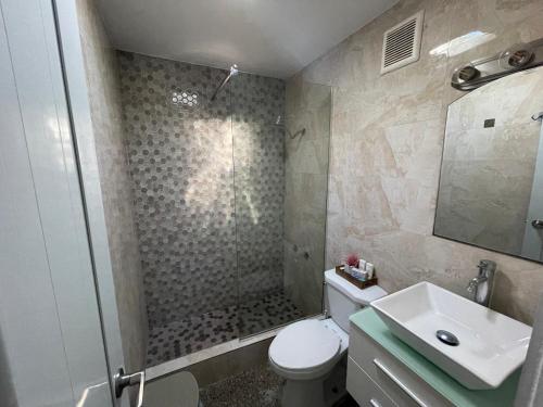 y baño con ducha, aseo y lavamanos. en “Lucor D-Eight House” New Entire Home in the Town… en Rincón