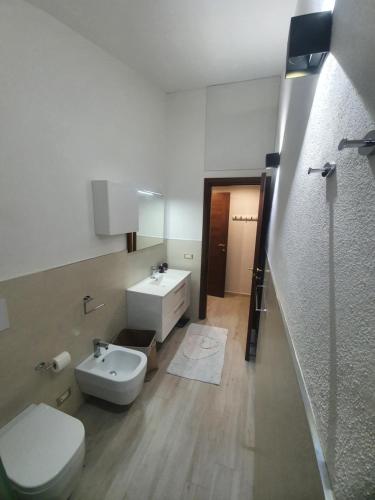 een badkamer met een wit toilet en een wastafel bij Appartamento Stangoni in Badesi