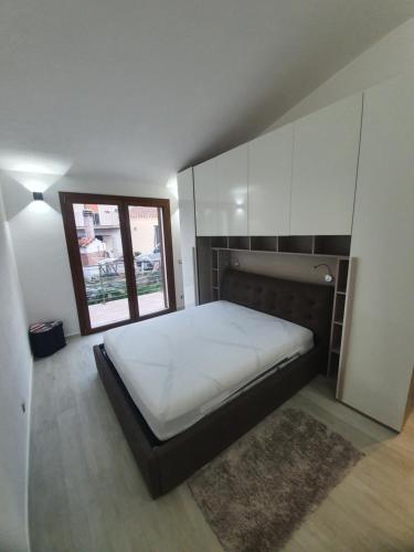 um quarto com uma cama grande e uma janela em Appartamento Stangoni em Badesi