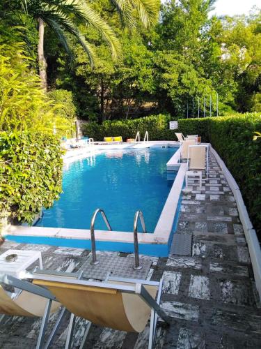 a swimming pool with two chairs and a table at Eurotel 406 in Rapallo