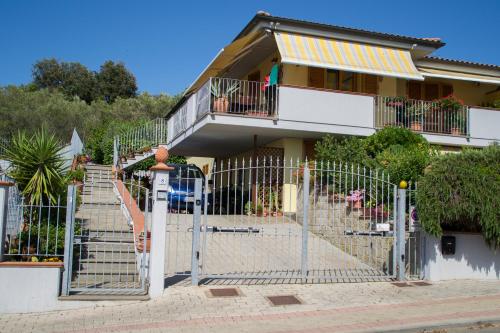 una recinzione di fronte a una casa con scala di Casa d'aMare - a 600 mt dalla spiaggia a Follonica