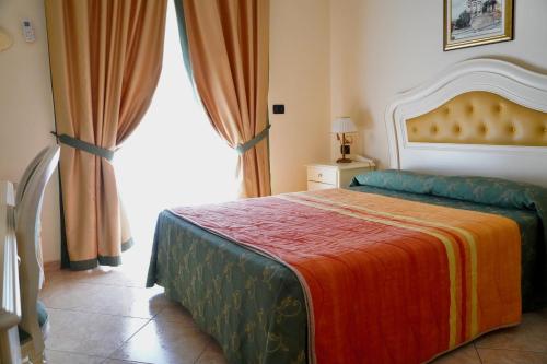 a bedroom with a bed and a large window at Hotel Roscianum Welness SPA in Rossano