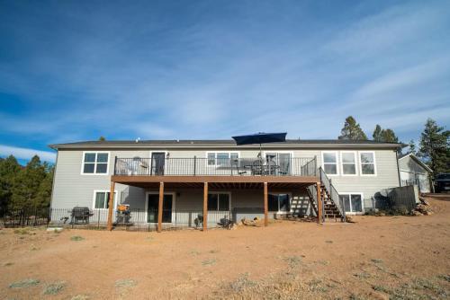 a large white house with a porch and a deck at 24 Quiver Circle Spectacular Mountain View 5 Acres PIKES PEAK in Florissant