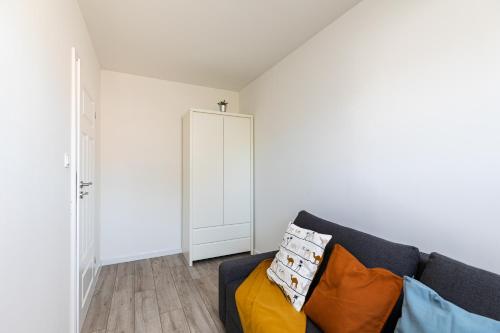 a living room with a couch and a door at SuperApart Obywatelska 42 in Warsaw