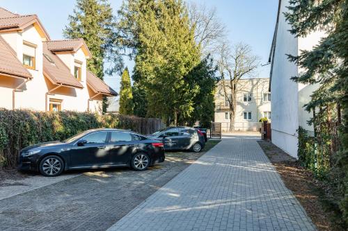 two cars parked on the side of a street at SuperApart Obywatelska 42 in Warsaw