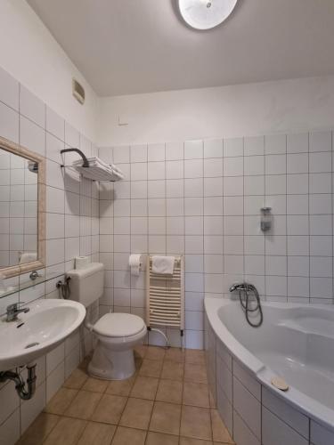 a bathroom with a tub and a toilet and a sink at BB Boutique Hotel in Újlengyel