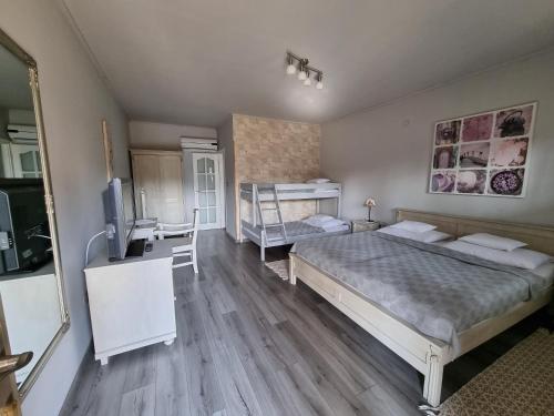 a bedroom with two beds and a desk and a television at BB Boutique Hotel in Újlengyel