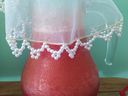 a red vase with a pearl necklace on it at Casa da Mineira Hospedaria in Lençóis