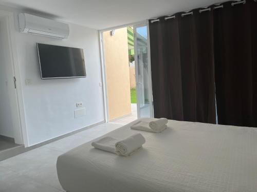 a bedroom with a bed with two towels on it at Precioso apartamento con piscina a 50m de la playa in Candelaria