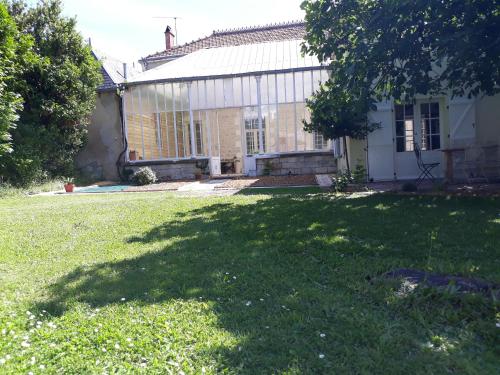 une maison avec une grande ombre dans la cour dans l'établissement La Maison de Maître, à Sainte-Soulle