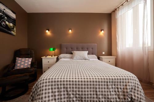 a bedroom with a bed with a checkered blanket at hotel de la paix in Pamiers