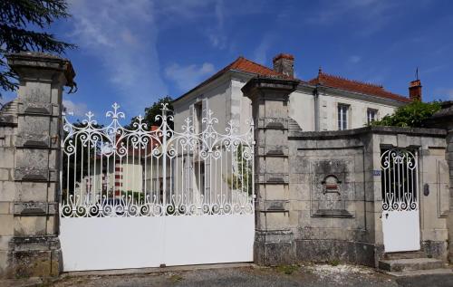 un portail blanc devant une maison dans l'établissement La Maison de Maître, à Sainte-Soulle