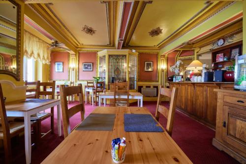 - une salle à manger avec une table et des chaises en bois dans l'établissement hotel de la paix, à Pamiers