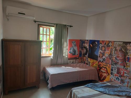 1 dormitorio con 2 camas y carteles en la pared en Apartamento em Lençóis Serrano 101, en Lençóis