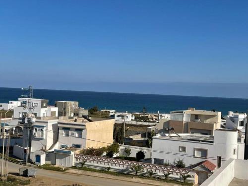 a group of white buildings with the ocean in the background at Magnifique villa El Haouaria-Nabeul in El Haouaria