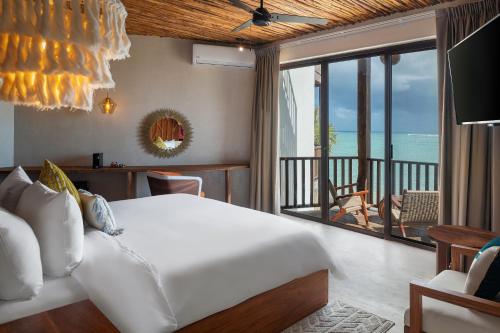 a bedroom with a bed and a view of the ocean at Nerea Tulum in Tulum