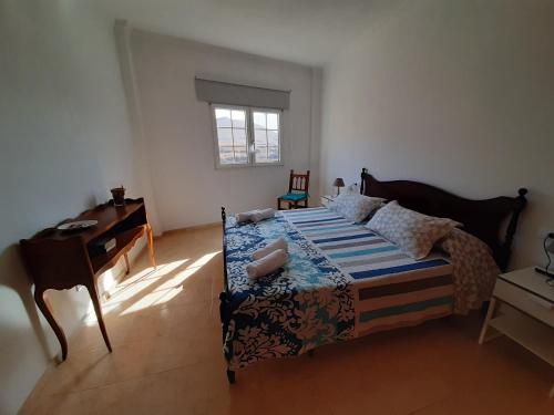 een slaapkamer met een bed, een bureau en een piano bij Atico en la Playa de La Aldea. in San Nicolás