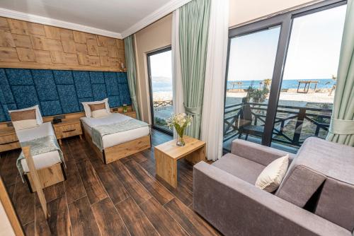 uma sala de estar com um sofá e uma cama em Assos Dove Hotel Resort & SPA em Behramkale