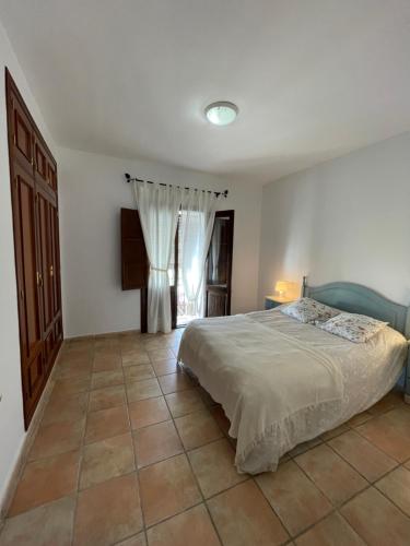 a bedroom with a bed and a tiled floor at Agradable casa rural con chimenea en interior in Higuera de la Sierra