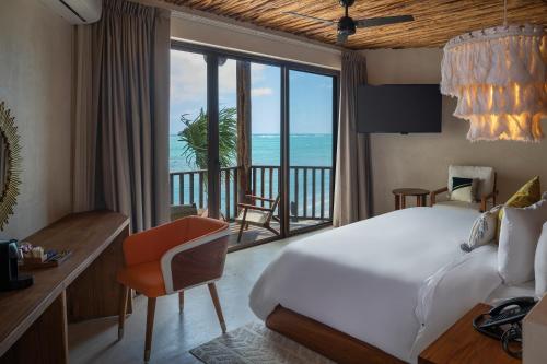 a bedroom with a bed and a view of the ocean at Nerea Tulum in Tulum