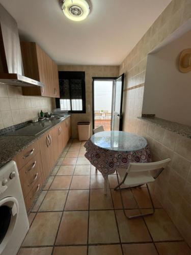 a kitchen with a table in the middle of it at Agradable casa rural con chimenea en interior in Higuera de la Sierra