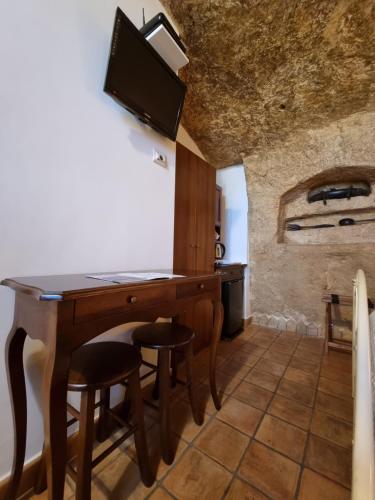 a dining room with a wooden table and stools at Torretta ai Sassi in Matera