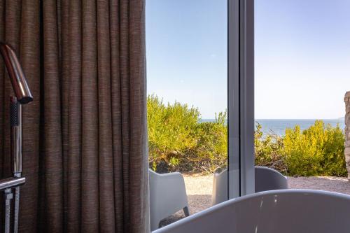 a room with a window with a view of the ocean at Seeplaas Guesthouse in Groot Brak Rivier