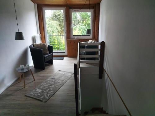 a living room with a ladder and a chair and a window at Ferienwohnung in Bad Segeberg