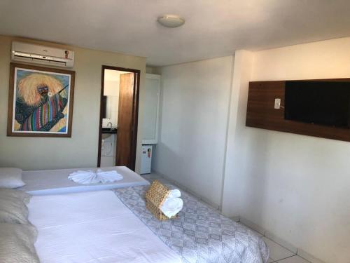 a room with two beds and a flat screen tv at Olinda mar pousada in Olinda