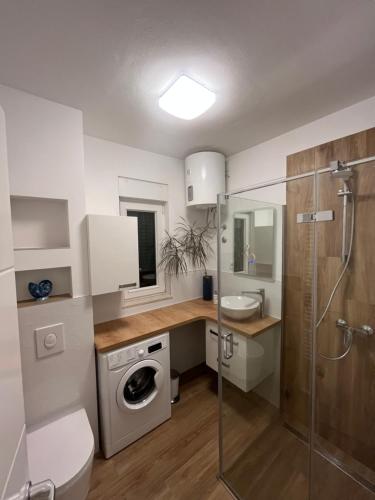 a bathroom with a washing machine and a sink at Apartment Trogir City in Trogir