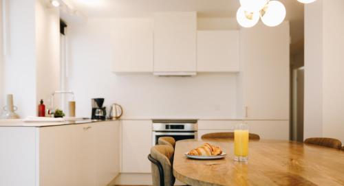 a kitchen with a wooden table with a glass of orange juice at Beautiful Apartments on Strøget in Copenhagen City Center in Copenhagen