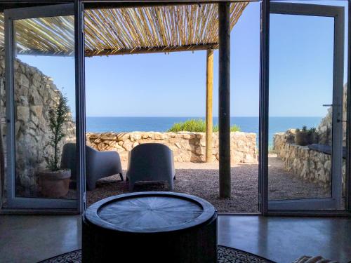 a room with a view of the ocean through glass at Seeplaas Guesthouse in Groot Brak Rivier