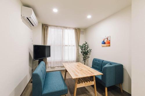a room with a table and two chairs and a television at TKD Asahikawa - Vacation STAY 24510v in Asahikawa