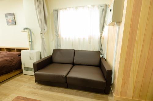 a brown couch in a room with a window at TKD Asahikawa - Vacation STAY 24510v in Asahikawa