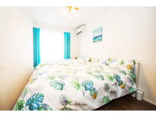 una camera da letto con un letto con copriletto floreale di Hill Top Hakone Iryuda 202 - Vacation STAY 11214 a Odawara