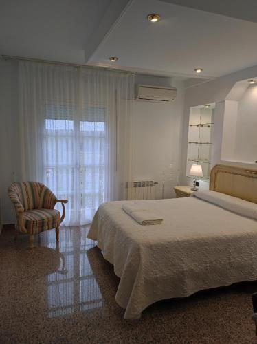 a bedroom with a bed and a chair and a window at Casa Rural Casa Valdecaballeros in Valdecaballeros