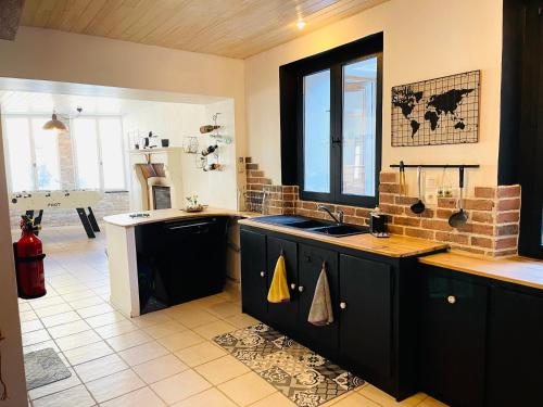 une cuisine avec un évier et un plan de travail dans l'établissement La Carrée des Amis, à Lusignan