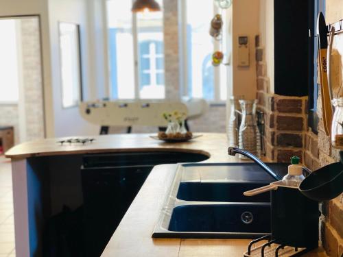 a kitchen with a sink and a counter top at La Carrée des Amis in Lusignan