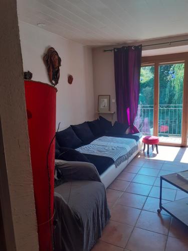 ein Wohnzimmer mit einem Bett und einem Sofa in der Unterkunft Maison de campagne à l'étage in Ser-Sigaud