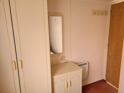 a small bathroom with a sink and a mirror at 6 Berth Promenade Ingoldmells (Mirage III) in Ingoldmells