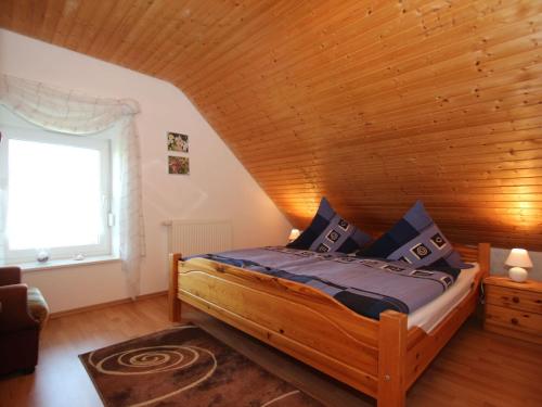 - une chambre avec un lit et un plafond en bois dans l'établissement Apartment, Essen, à Esens