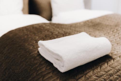 a white towel sitting on top of a bed at Beautiful Apartments on Strøget in Copenhagen City Center in Copenhagen