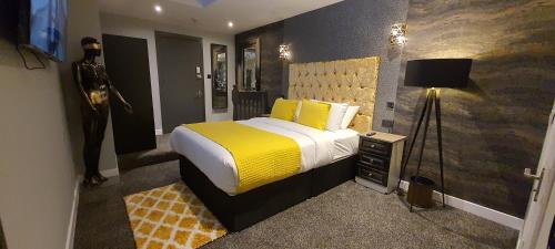 a bedroom with a large bed with a yellow blanket at The Gate Hotel in Dublin