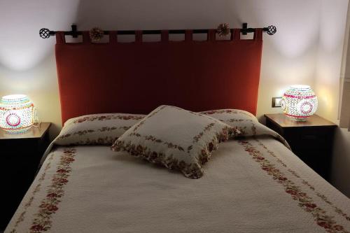 um quarto com uma cama com uma cabeceira vermelha e 2 candeeiros em El Mirador Vistas muy bonitas em Breña Baja