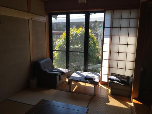 een woonkamer met een stoel en een raam bij Hagioen - Vacation STAY 20253v in Uki