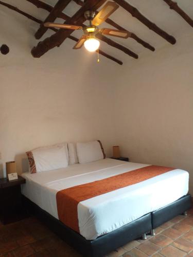 a bedroom with a bed with a ceiling fan at Casona CHARA in Barichara